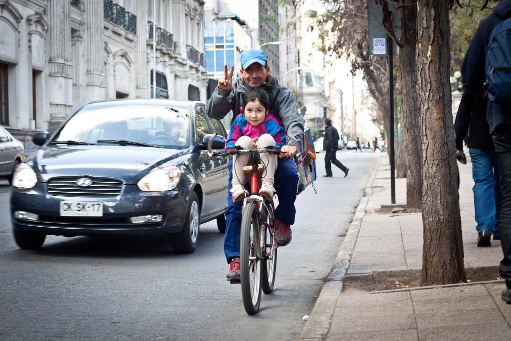 Un hombre y una niña comparten la bicicleta en Santiago